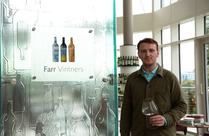 Patrick from Farr Vintners posing with a wine glass at the entrance to their offices in Battersea 