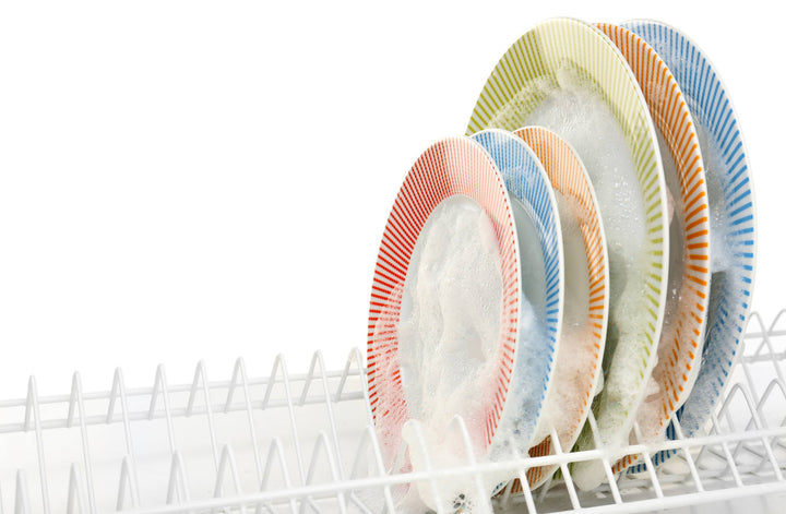 Plates in a dishwasher rack covered in soapy foam
