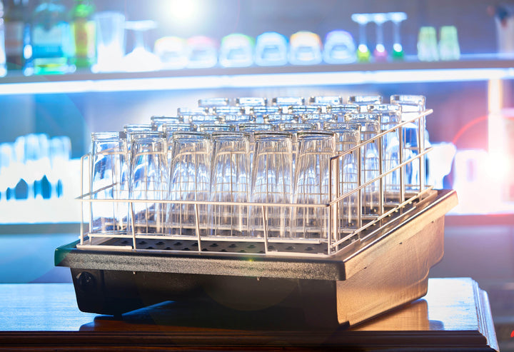 A glass dryer rack of sparkling clean pint glasses 